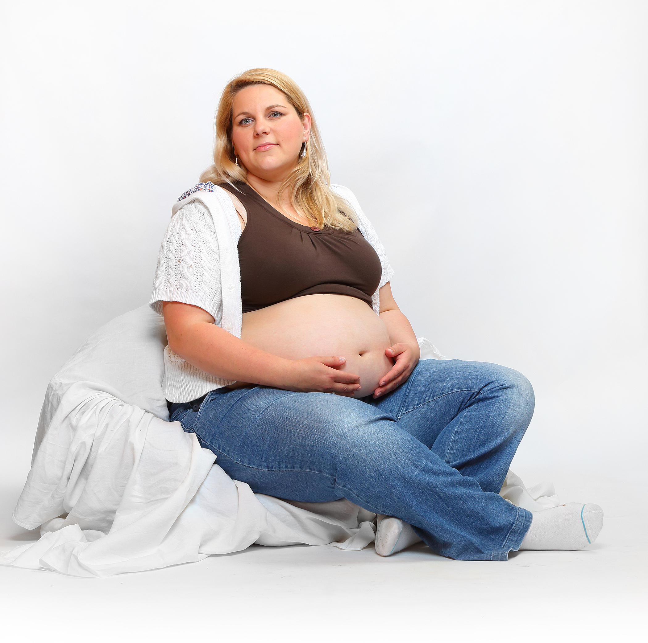 Overweight pregnant woman relaxing in the bedroom. Health and body care concept. Unhealthy lifestyle problems.